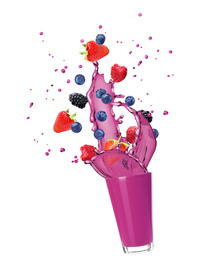 Delicious berry juice splashing out of glass on white background