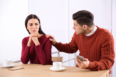 Unhappy couple with relationship problems at table in cafe