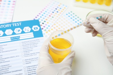 Doctor doing urine analysis at white table