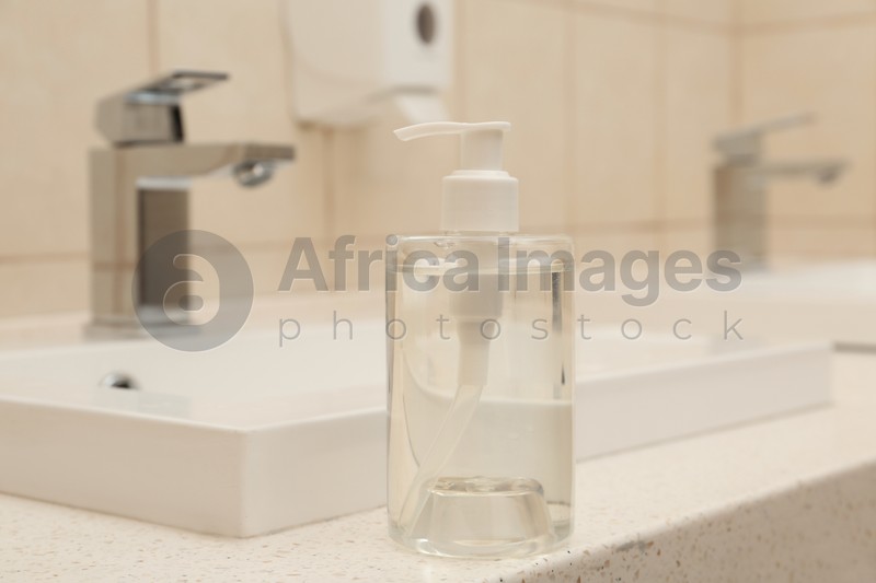 Dispenser bottle with antiseptic gel in public bathroom