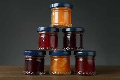 Jars of different jams on wooden table