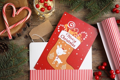 Flat lay composition with Christmas card and festive  decor on wooden background