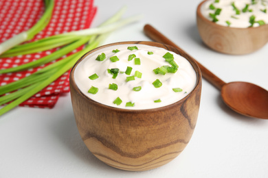 Fresh sour cream with onion on white table