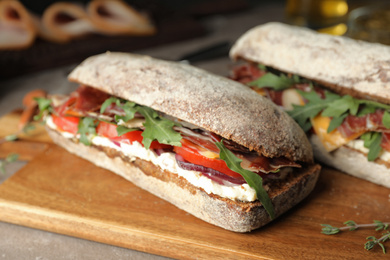 Photo of Delicious sandwiches with fresh vegetables and prosciutto on table, closeup