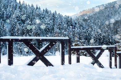 Snowflakes falling on wooden fence in winter, bokeh effect