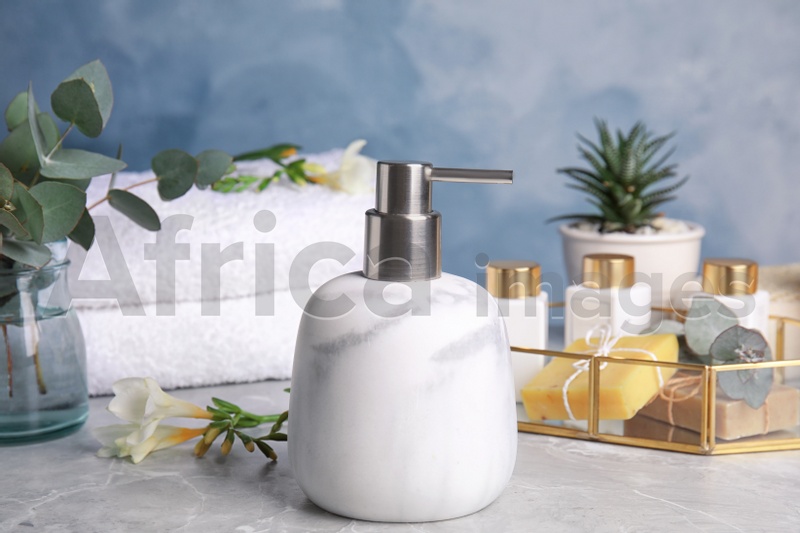 Marble soap dispenser and toiletries on grey table