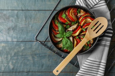 Photo of Delicious ratatouille on light blue wooden table, top view. Space for text