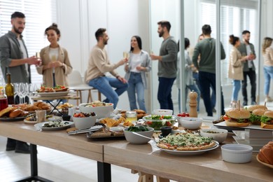 Brunch table setting with different delicious food	and blurred view of people on background