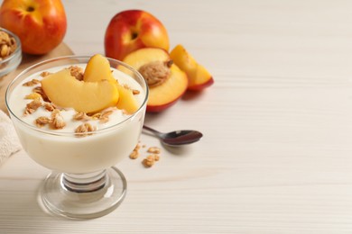Photo of Tasty peach yogurt with granola and pieces of fruit in dessert bowl on white wooden table, space for text