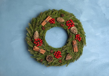 Beautiful Christmas wreath on light blue wall