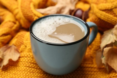 Photo of Cup of coffee on warm plaid, closeup view