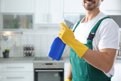 Janitor with sprayer in kitchen, closeup. Cleaning service