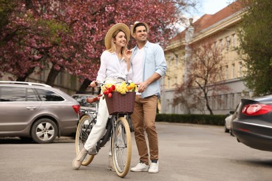 Lovely couple with bicycle and flowers on city street