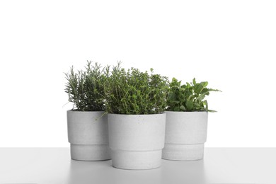 Pots with thyme, mint and rosemary on white background