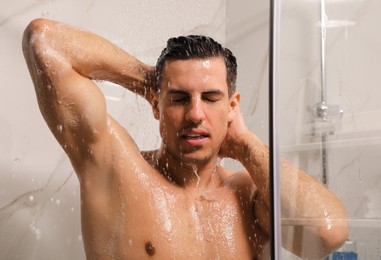Photo of Handsome man taking shower at home. Morning routine