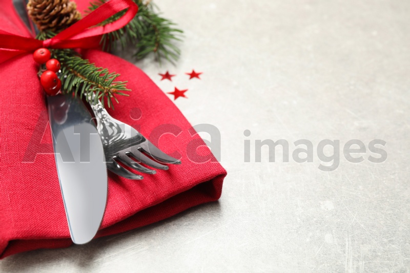 Cutlery set and Christmas decor on light grey table, closeup. Space for text