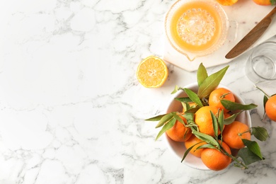 Flat lay composition with ripe tangerines and juicer on marble background. Space for text