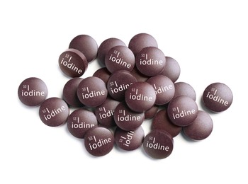 Iodine pills on white background, top view. Mineral element
