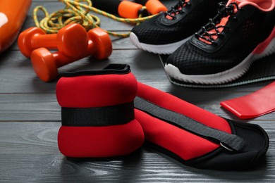 Red weighting agents and sport equipment on grey wooden table