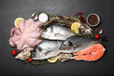 Photo of Flat lay composition with fresh raw dorado fish and different seafood on black table