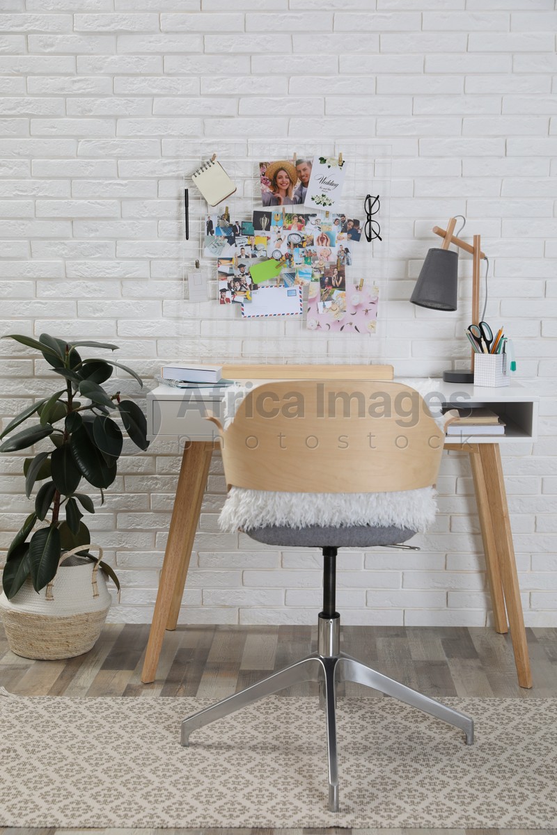 Stylish room interior with workplace and vision board