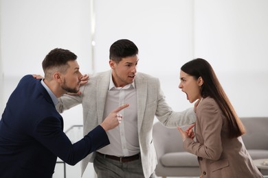 Man setting his fighting colleagues apart in office