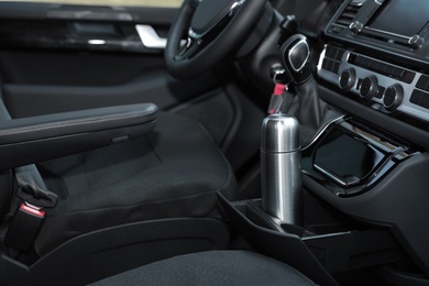 Silver thermos in holder inside of car