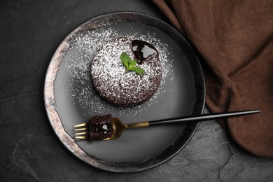 Delicious fresh fondant with hot chocolate and mint on black table, top view