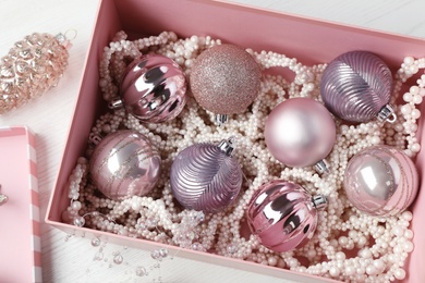 Beautiful Christmas baubles on white wooden table, above view