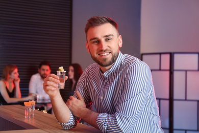Young man with Mexican Tequila shot at bar