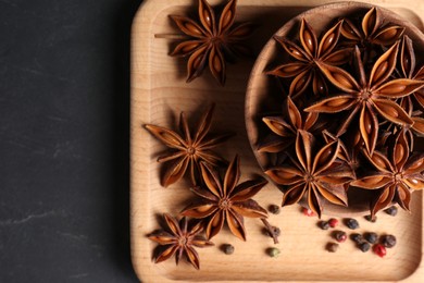 Aromatic anise stars and spices on wooden board, top view
