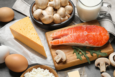 Fresh products rich in vitamin D on grey table