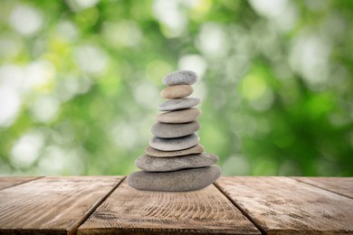 Stacked stones on wooden table against blurred background. Zen concept