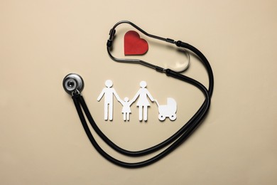 Photo of Paper family figures, red heart and stethoscope on beige background, flat lay. Insurance concept