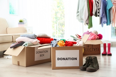 Donation boxes with clothes on floor in living room