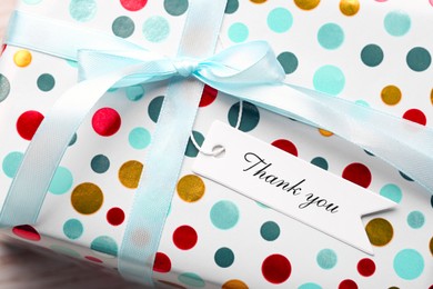 White tag with phrase Thank You on gift box, closeup