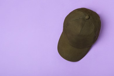 Baseball cap on violet background, top view. Space for text