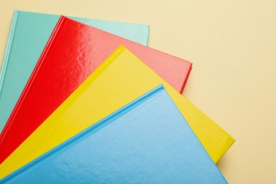 New colorful planners on beige background, top view