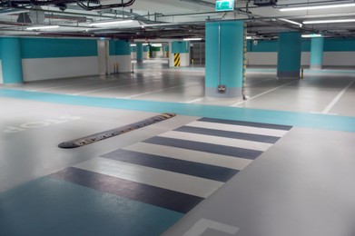 Photo of Empty car parking garage with pedestrian crossing and columns
