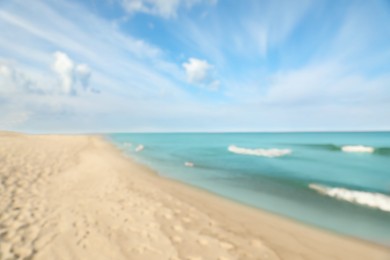 Photo of Blurred view of sea shore and blue sky on sunny day