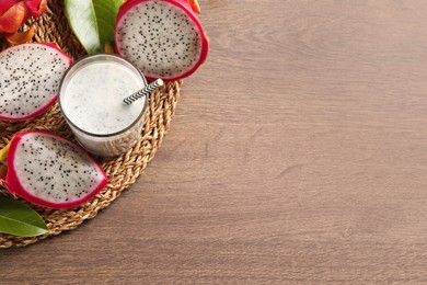 Delicious pitahaya smoothie and fresh fruits on wooden table, top view. Space for text