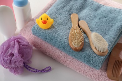 Photo of Towels, rubber duck and baby care products on white table