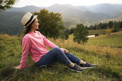 Young woman enjoying beautiful view of mountain landscape