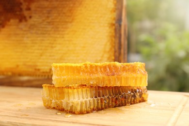 Photo of Fresh delicious honeycombs on wooden table outdoors