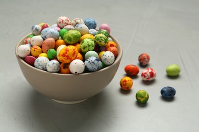 Ceramic bowl with delicious candies on grey table, closeup. Cooking utensil