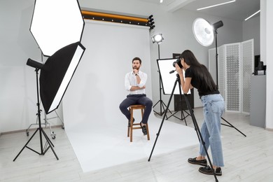 Photo of Handsome model posing for professional photographer in studio