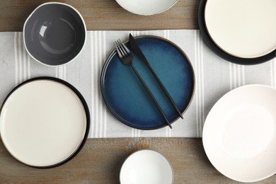 Photo of Set of clean dishware on wooden table, flat lay