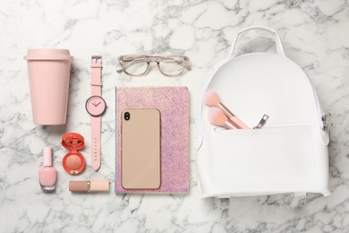 Stylish urban backpack and different items on white marble table, flat lay