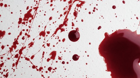 Stain and splashes of blood on light grey background, top view