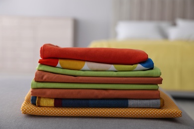 Stack of new clean folded bed linens on bench